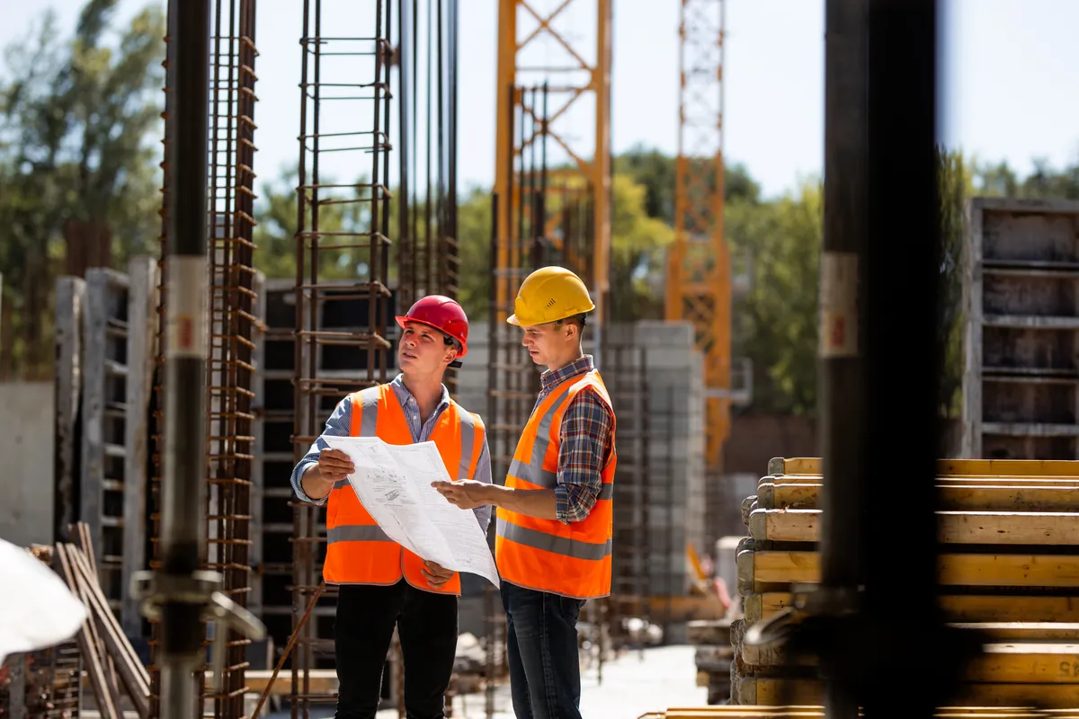 Dos responsables de obra revisan planos en el sitio de construcción