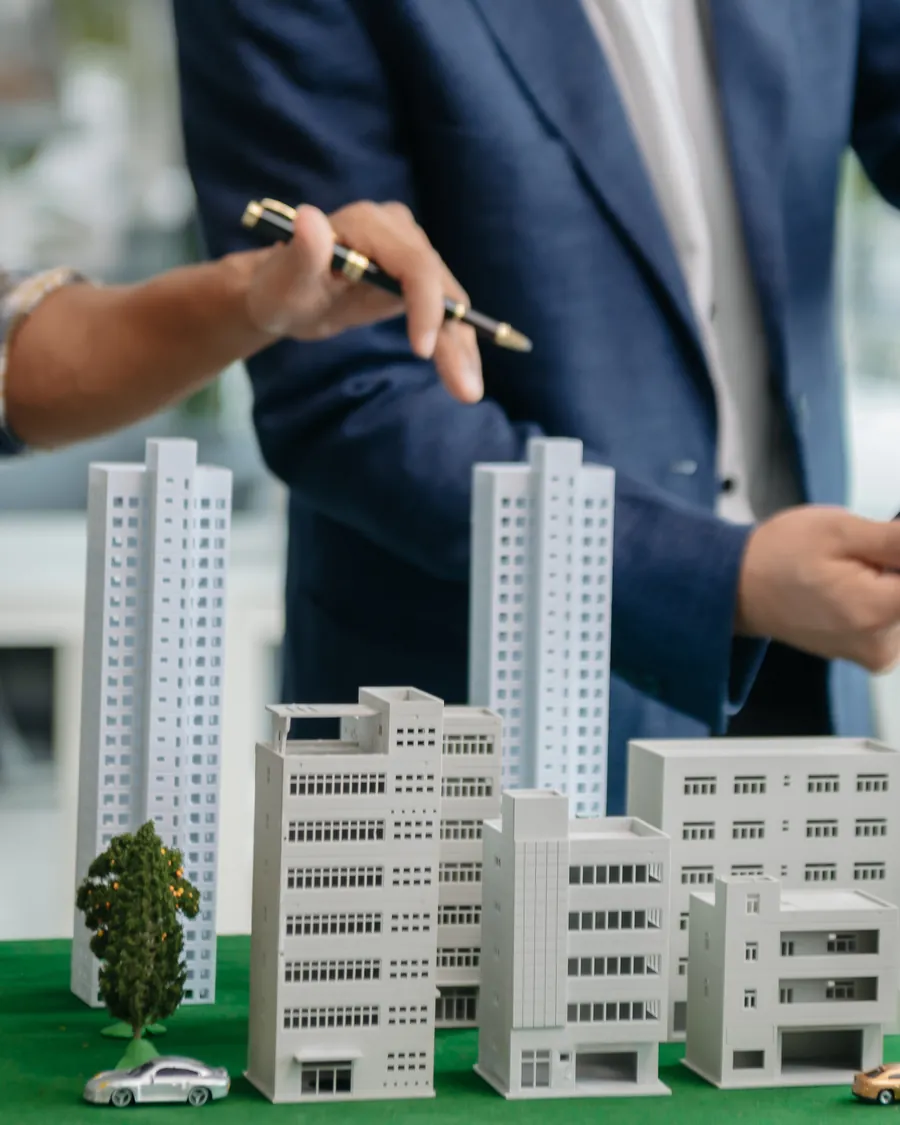 Dos profesionales revisan la maqueta de un desarrollo sobre una mesa de trabajo